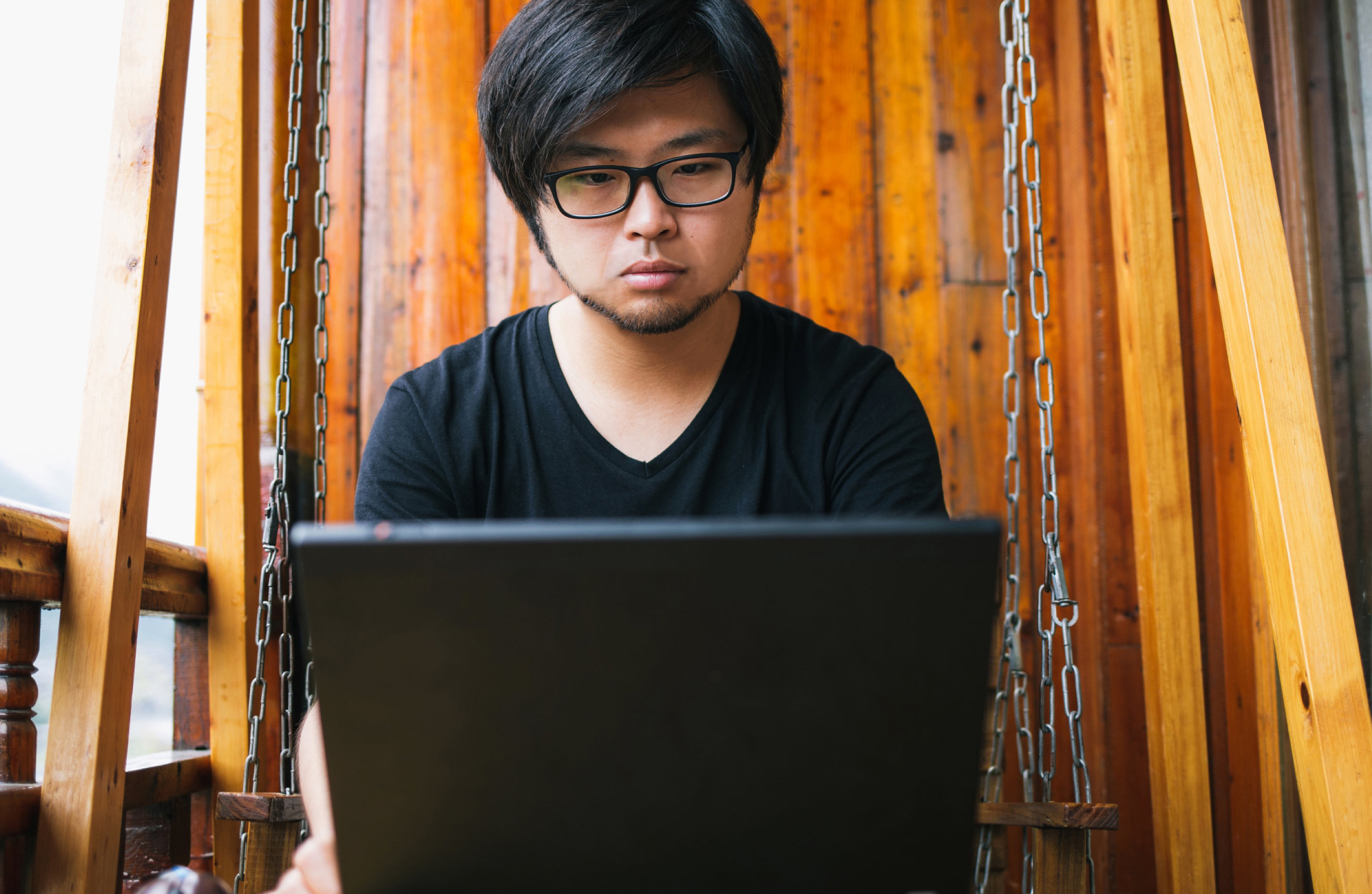 Asian man looking at laptop