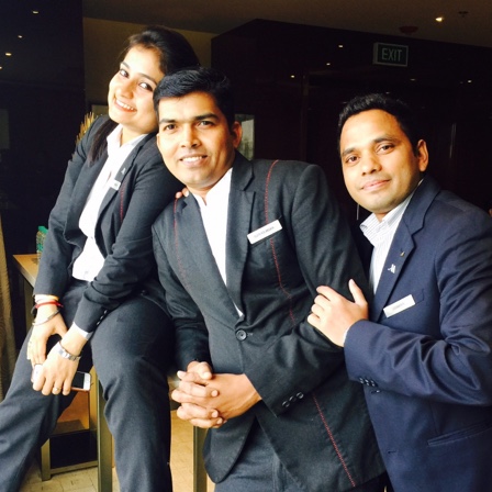 três funcionários do hotel usando uniforme e sorrindo