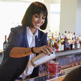 Female bartender pouring cocktails