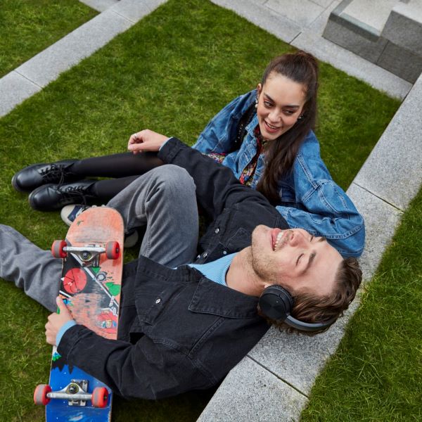 年轻情侣坐在长有绿草的台阶上